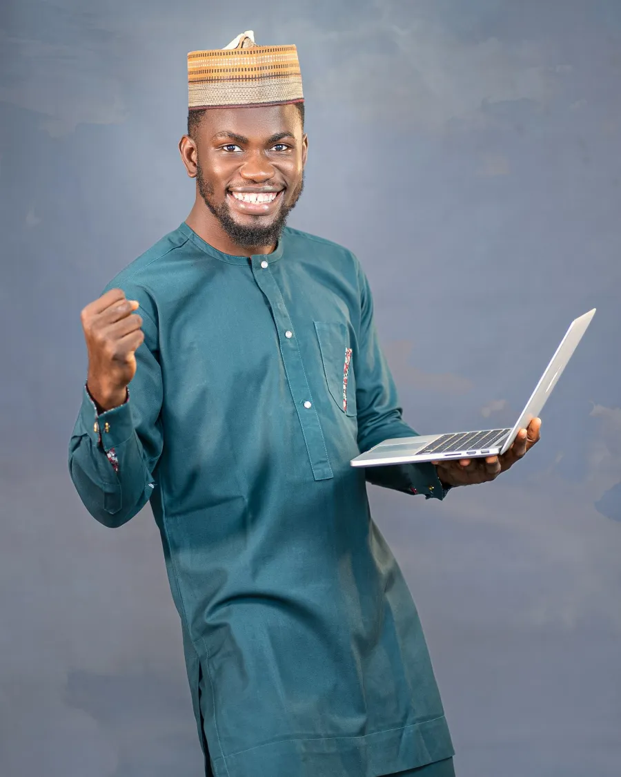 Entrepreneur souriant, ordinateur portable en main, qui célèbre la réussite de son projet numérique